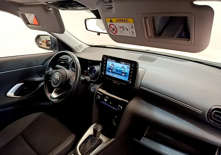 Intérieur avant droit de la Toyota Yaris Cross 2022, tableau de bord avec écran tactile et volant multifonctions cuir.