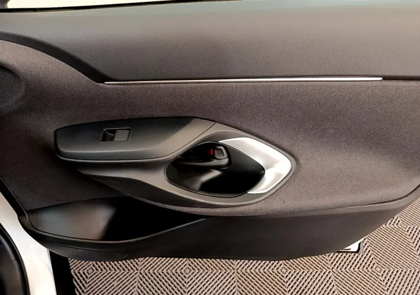 Poignée intérieure de porte côté gauche en plastique noir et argent sur Toyota Yaris Cross blanc 2022.