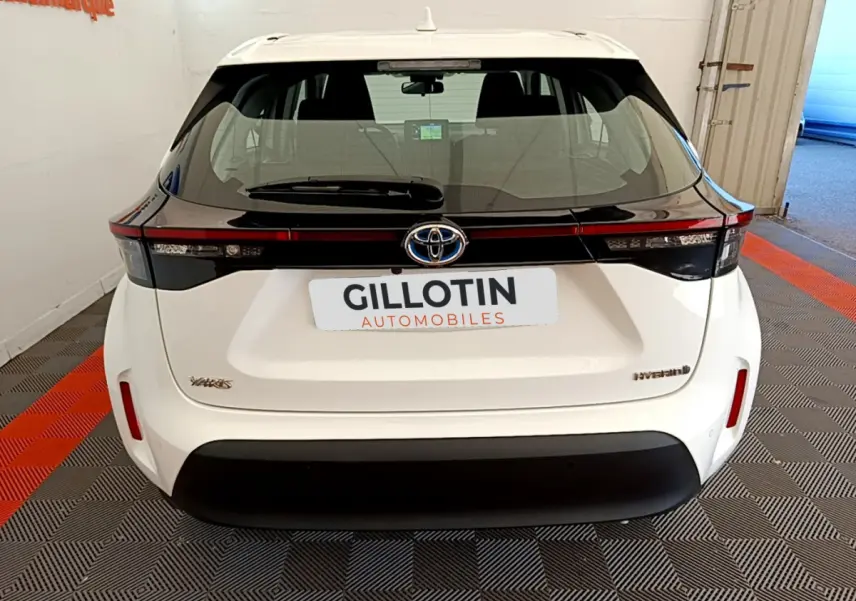 Vue arrière d'une Toyota Yaris Cross blanche avec bandeau noir et logo Toyota centré sur le hayon.