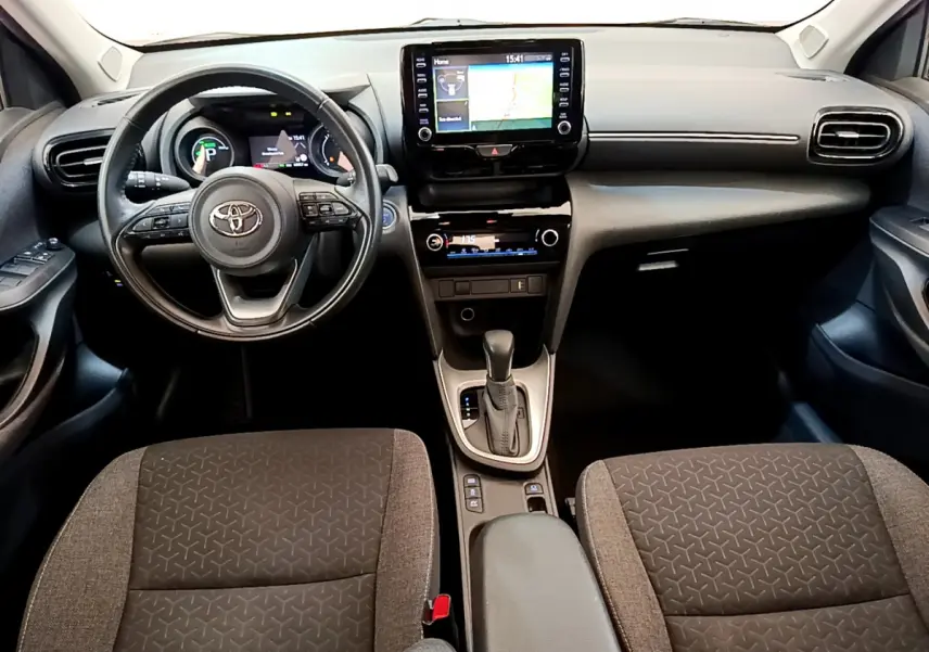 Intérieur de la Toyota Yaris Cross 2022, vue frontale du tableau de bord avec volant cuir et écran tactile central.