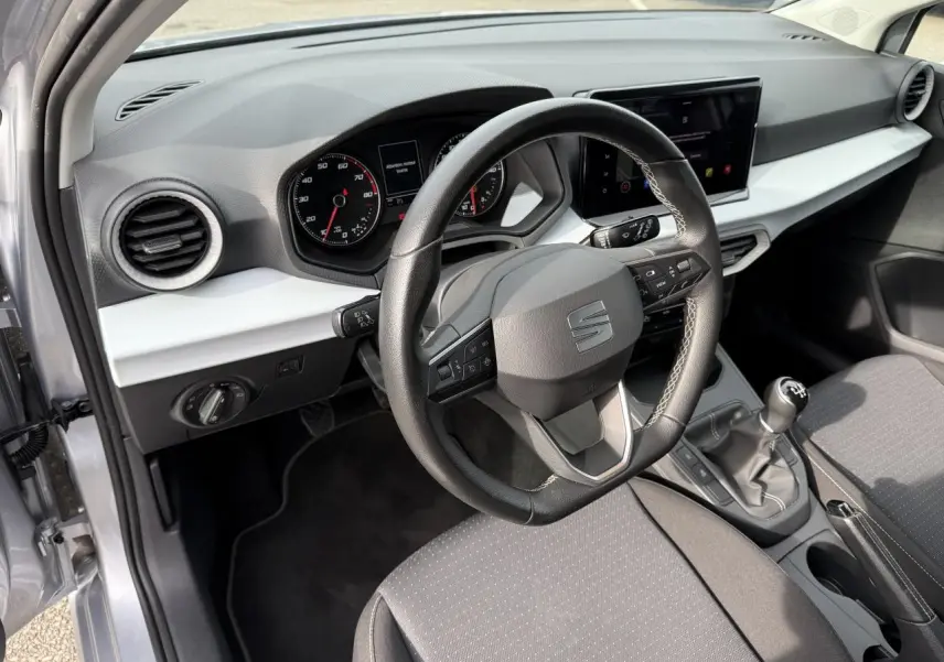 Vue intérieure côté conducteur de la SEAT Ibiza 2022 argent Urban avec tableau de bord moderne et boîte manuelle.