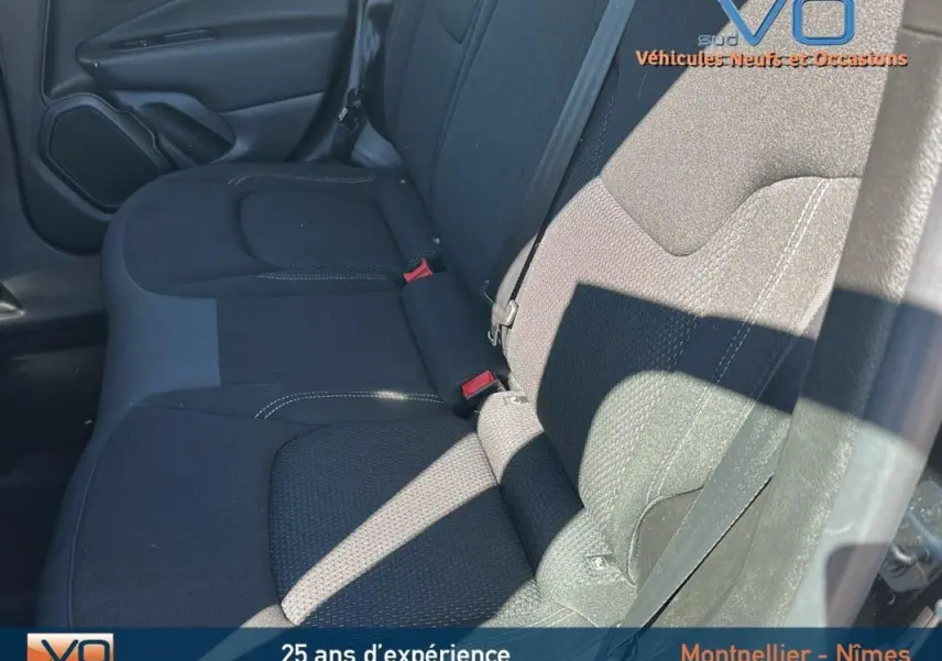 Vue rapprochée des sièges arrière noirs du Jeep Renegade 2024, montrant la texture du tissu et la ceinture de sécurité côté droit.