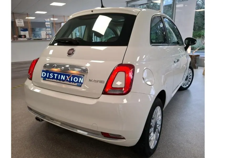 Vue 3/4 arrière droite de la FIAT 500 blanche Bossa Nova avec badge Hybrid, en intérieur showroom.