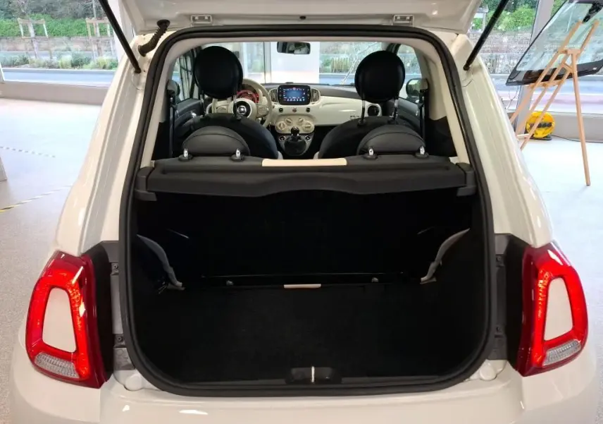 Vue arrière ouverte de la FIAT 500 blanche Bossa Nova, montrant le coffre vide et l’intérieur avec tableau de bord clair.