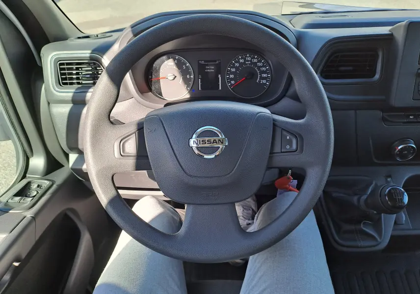 Vue intérieure centrée sur le volant Nissan et le tableau de bord du Nissan Interstar Chassis Cabine 2024, boîte manuelle.