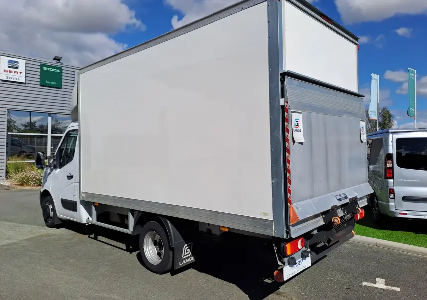 Vue 3/4 arrière droite d’un Nissan Interstar châssis cabine blanc avec hayon élévateur, stationné en extérieur.