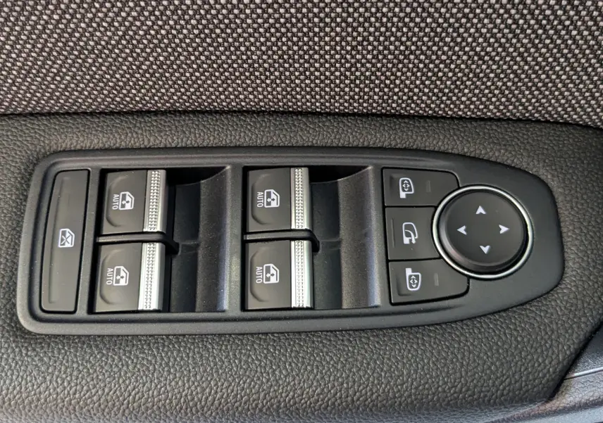 Panneau de commandes des vitres et rétroviseurs côté conducteur du Renault Captur E-Tech blanc nacré avec toit noir, finition 2025.