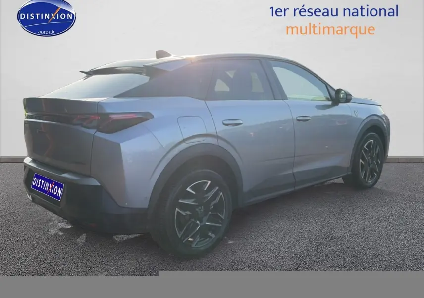 Vue 3/4 arrière droite d'un Peugeot 3008 gris 2025 avec jantes alu noires et becquet arrière distinctif.