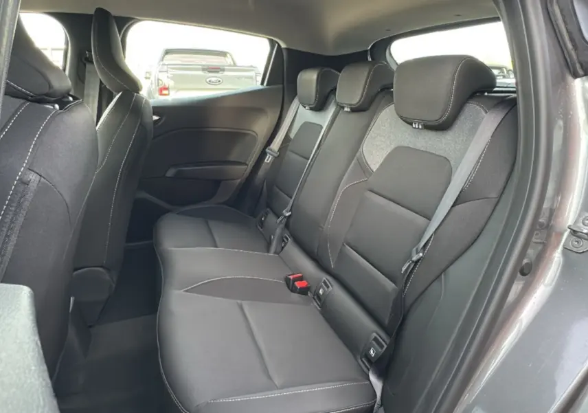 Vue intérieure sur la banquette arrière noire de la Renault Clio gris schiste, avec ceinture et appuie-têtes visibles.