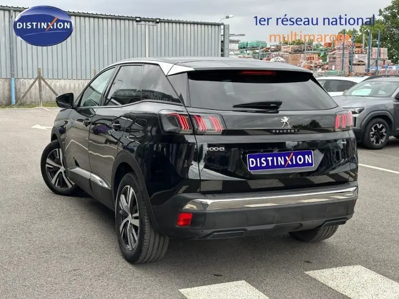 Vue 3/4 arrière d’un Peugeot 3008 noir Perla Nera avec feux arrière LED et jantes alliage sur parking.