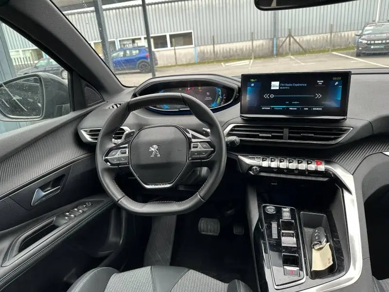 Vue intérieure du poste de conduite du Peugeot 3008 Hybride Rechargeable 2024, avec volant cuir multifonction et écran tactile central.