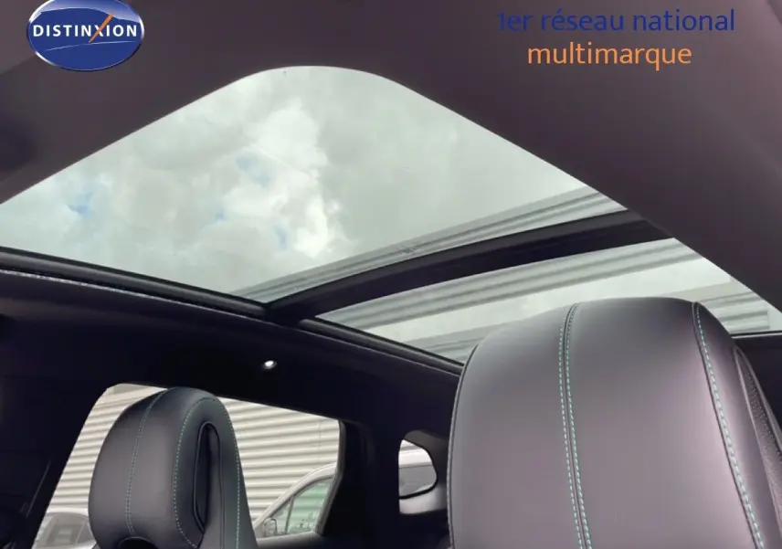 Vue intérieure sur les sièges avant en cuir noir avec surpiqûres vertes et toit panoramique ouvert du BYD SEAL U.