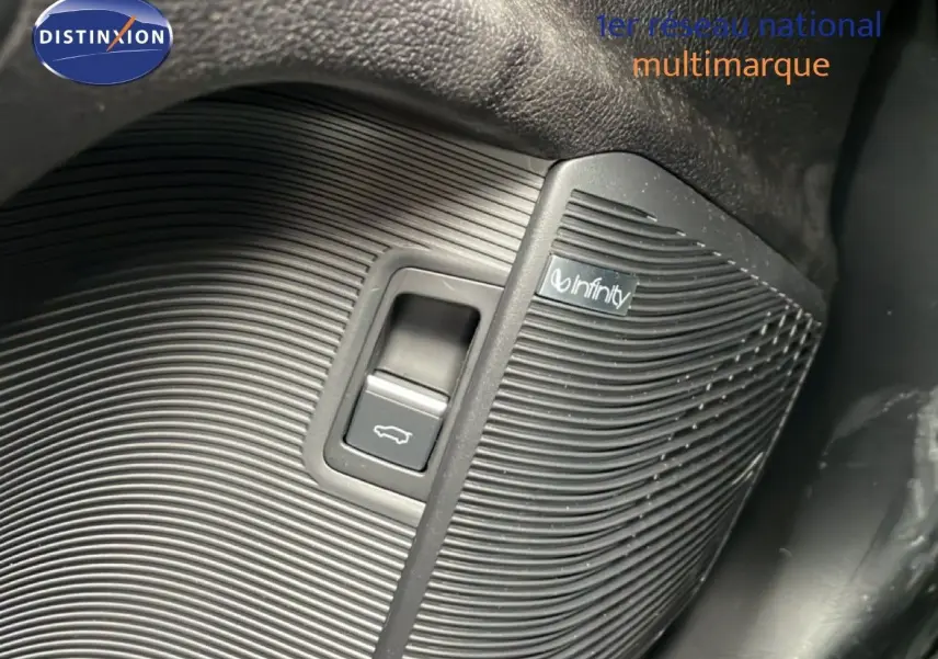 Détail du bouton d'ouverture de coffre avec haut-parleur Infinity intégré dans l'habitacle noir du BYD SEAL U.