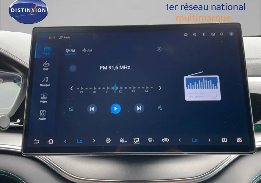 Vue intérieure centrée sur l'écran tactile du tableau de bord du BYD SEAL U gris, affichant la radio FM 91,6 MHz.