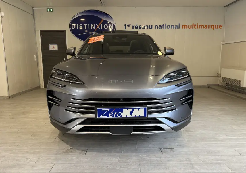 Vue frontale d'un BYD SEAL U 2026 gris métallisé avec calandre horizontale et phares LED fins en showroom.