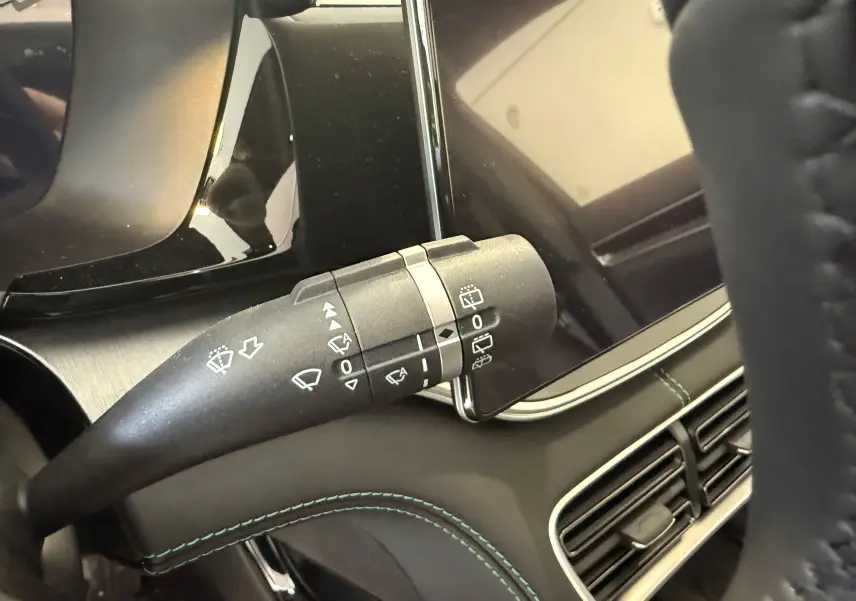 Gros plan sur la commande des essuie-glaces dans l’habitacle noir du BYD SEAL U 2026, avec coutures vertes visibles.