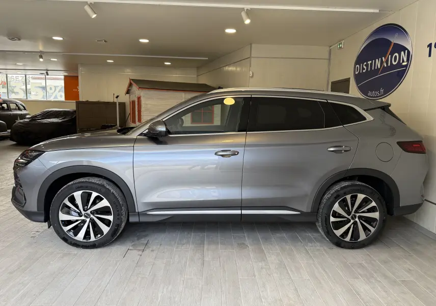 Vue de profil droit du SUV BYD SEAL U hybride rechargeable en gris métallisé, avec jantes bicolores et vitres teintées.