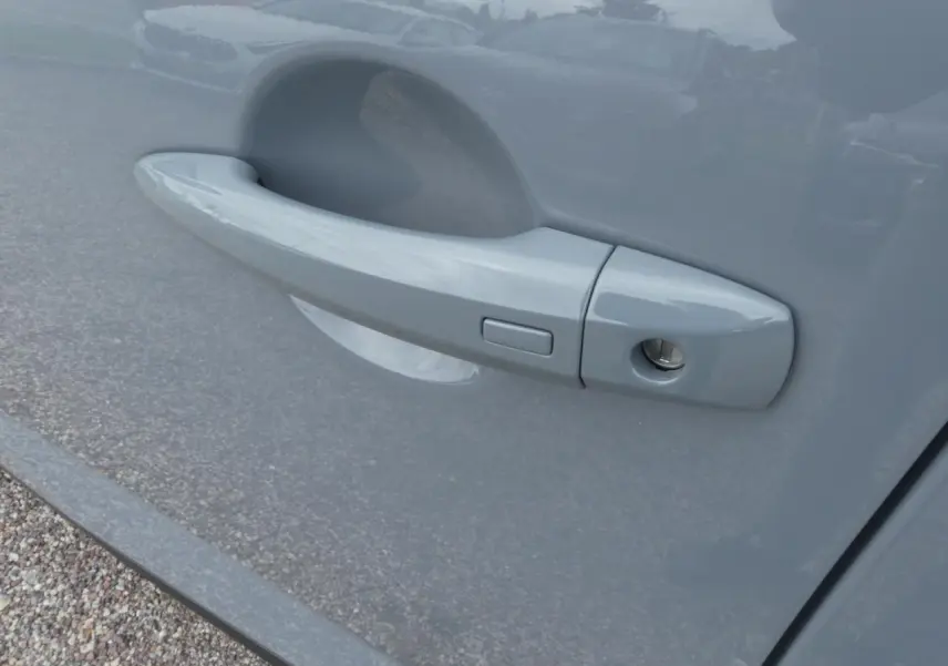 Poignée de porte côté gauche gris métallisé du Nissan Qashqai 1.5 e-Power N-Connecta 2025 avec bouton d'ouverture.