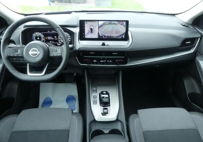 Vue intérieure du tableau de bord et console centrale du Nissan Qashqai 2025, finition N-Connecta, avec écran tactile et volant cuir.