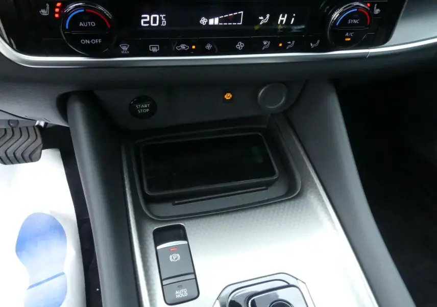 Gros plan sur la console centrale du Nissan Qashqai 1.5 e-Power 2025 avec commandes climatisation et frein électrique.