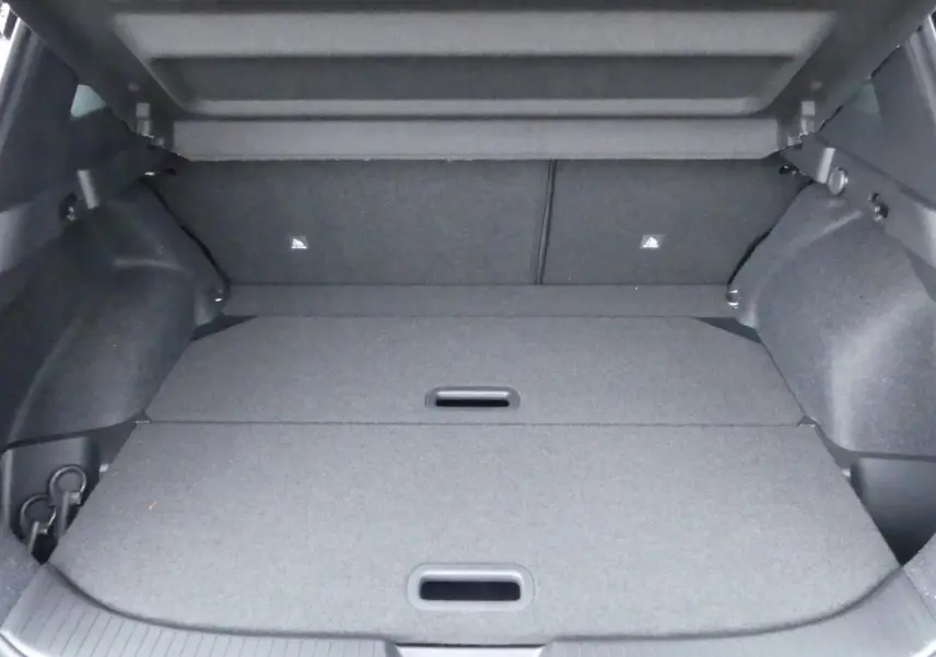 Coffre spacieux du Nissan Qashqai 1.5 e-Power gris métallisé avec plancher modulable et crochets de fixation visibles.