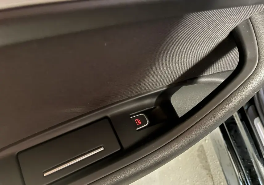 Bouton de verrouillage électrique sur la poignée intérieure côté gauche d'une Audi A6 Avant noire de 2017.