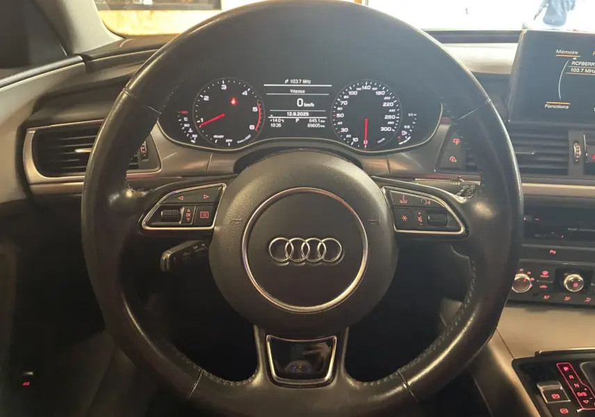 Vue frontale du volant noir en cuir de l'Audi A6 Avant 2017 avec tableau de bord digital et commandes intégrées.