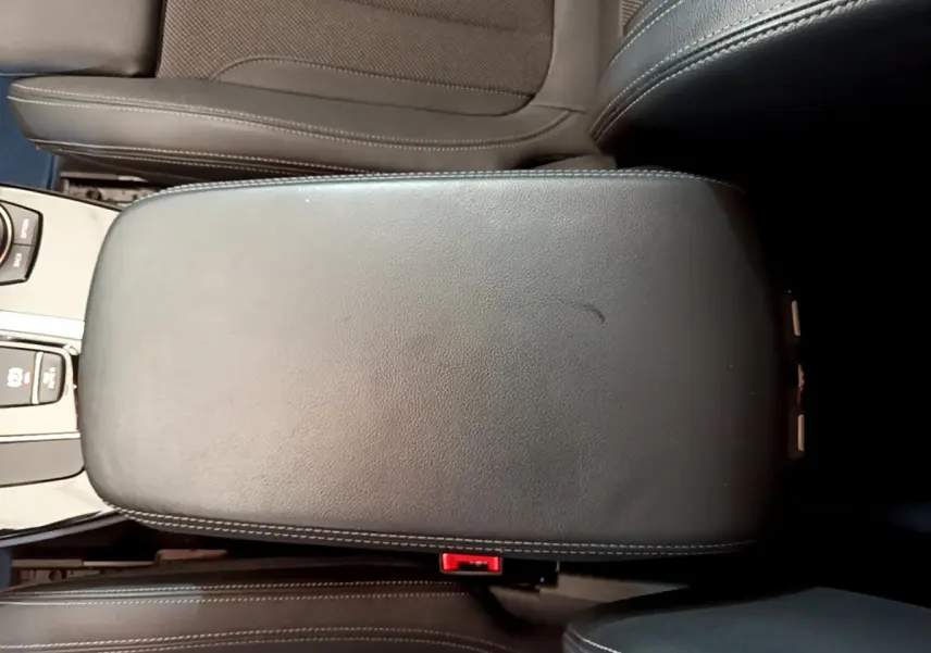 Vue plongeante sur l'accoudoir central en cuir noir avec surpiqûres blanches du BMW X3 xDrive20d 2020.