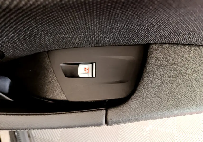 Gros plan sur le bouton de verrouillage des vitres côté intérieur d'une BMW X3 noire xDrive20d 2020.