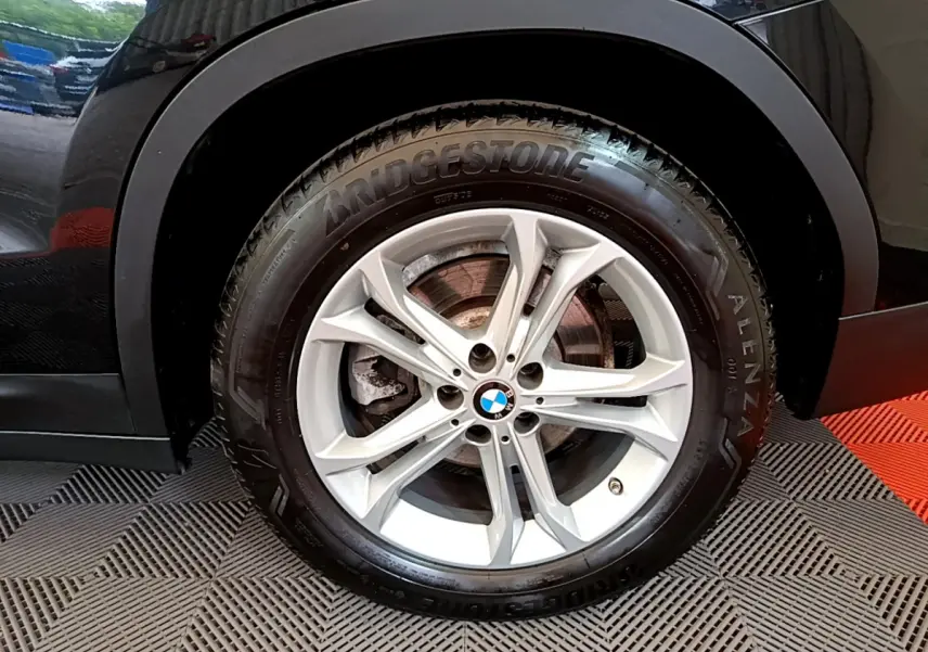 Gros plan sur la roue avant droite noire du BMW X3 xDrive20d 2020 avec jante alliage et pneu Bridgestone Alenza.