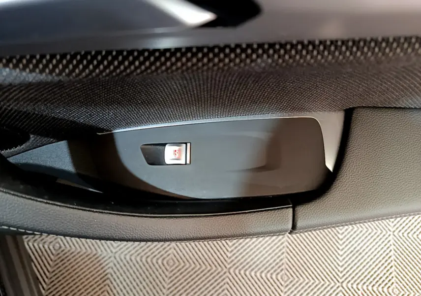 Gros plan sur le bouton de verrouillage centralisé dans la portière intérieure noire d'un BMW X3 xDrive20d 2020.