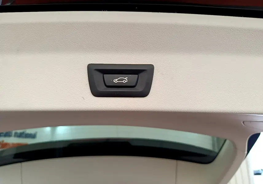 Bouton d'ouverture électrique du coffre sur la partie intérieure du hayon d'un BMW X3 noir xDrive20d 2020.