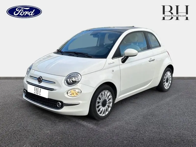 Fiat 500 blanche vue en 3/4 avant droit, avec toit panoramique en verre et jantes alu distinctives.