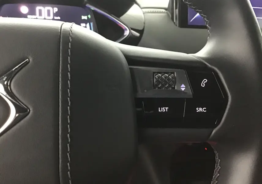 Gros plan sur la partie droite du volant en cuir noir du DS3 Crossback E-TENSE 2021 avec commandes audio et téléphone.