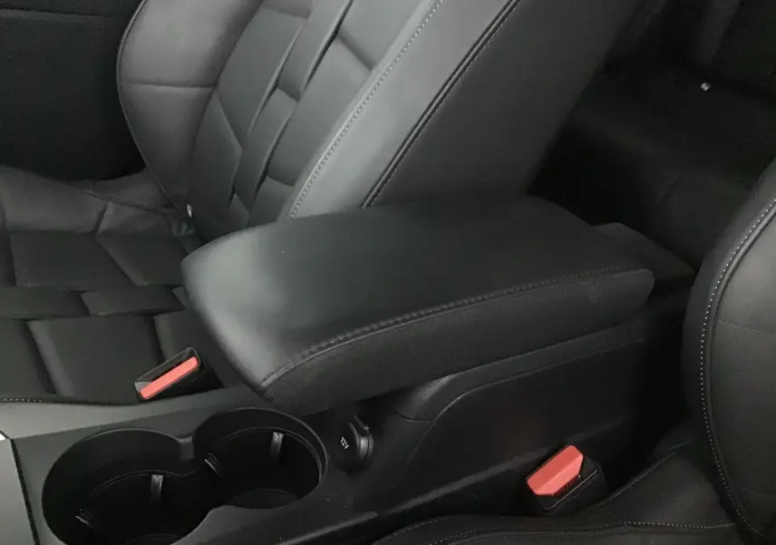 Gros plan sur l'accoudoir central en cuir noir et les sièges avant du DS3 Crossback E-TENSE 2021.