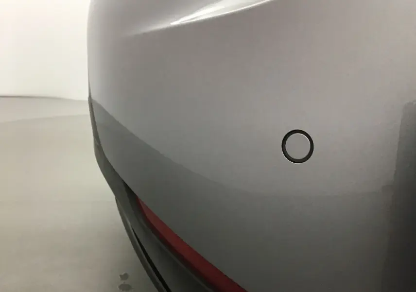 Gros plan sur le pare-chocs arrière gris Artense du DS3 Crossback E-TENSE avec capteur de recul circulaire visible.