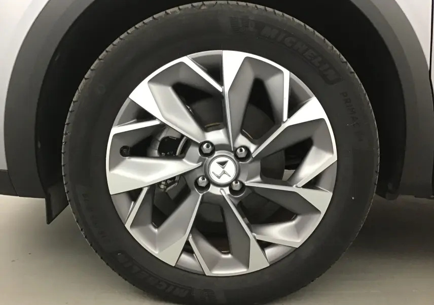 Gros plan sur la jante 18 pouces en alliage du DS3 Crossback gris Artense, mettant en valeur le design moderne et le pneu Michelin.