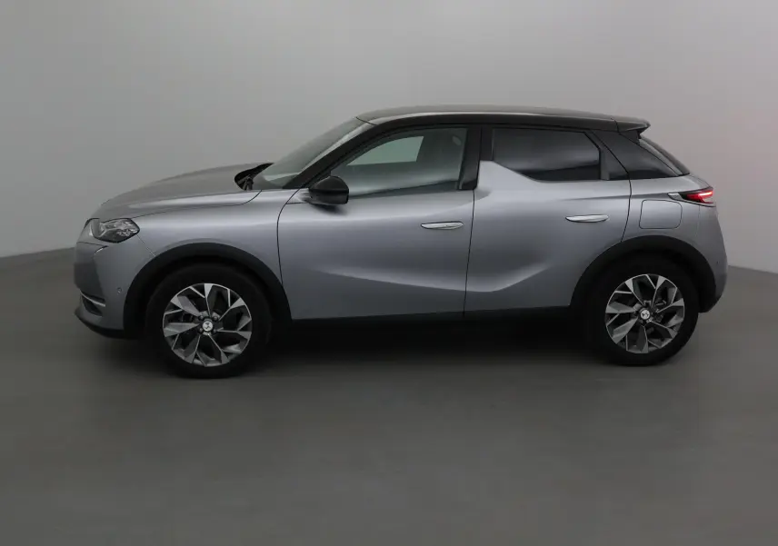 Profil côté gauche du DS3 Crossback E-TENSE 2021 en gris Artense avec jantes alliage et toit noir contrasté.