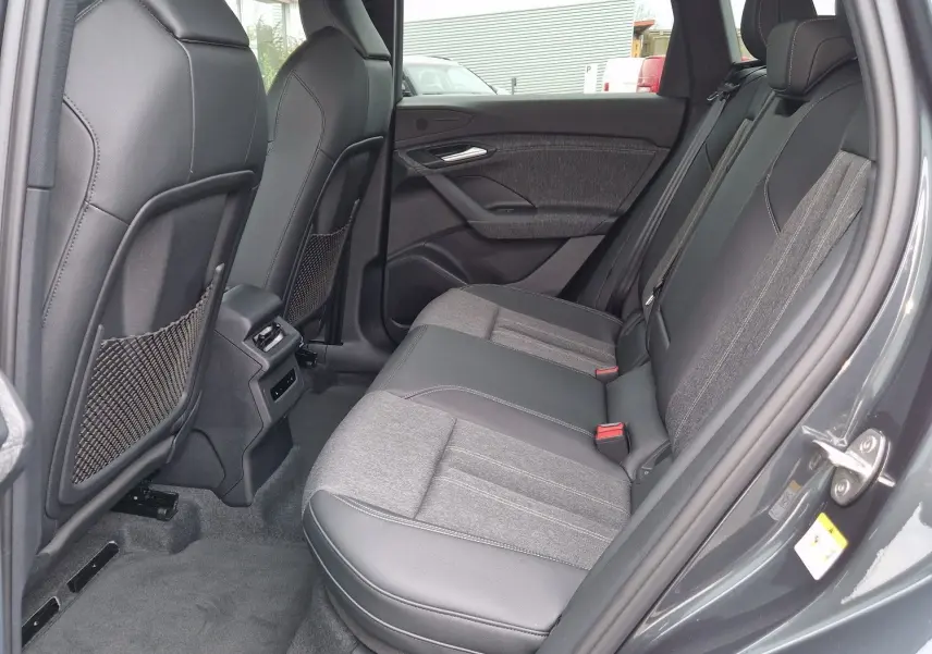 Vue intérieure côté droit des sièges arrière en tissu et cuir gris d'un Audi Q6 e-tron Performance S-Line 2025.