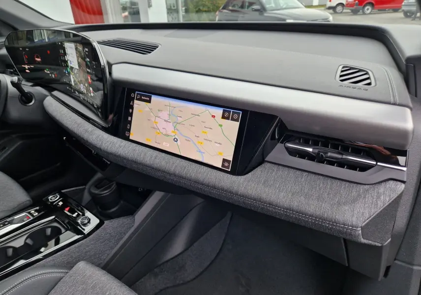 Intérieur de l'Audi Q6 e-tron Performance S-Line 2025, tableau de bord moderne avec écran tactile et finition tissu gris.