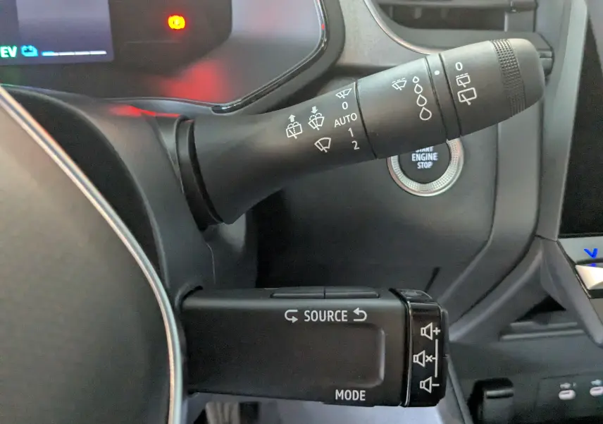 Gros plan sur les commandes au volant du Renault Captur gris Cassiopée 2025, avec bouton start/stop visible.