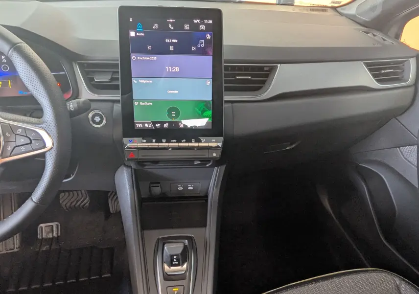 Intérieur du Renault Captur E-Tech 160ch 2025, tableau de bord moderne avec écran tactile vertical et volant multifonction noir.
