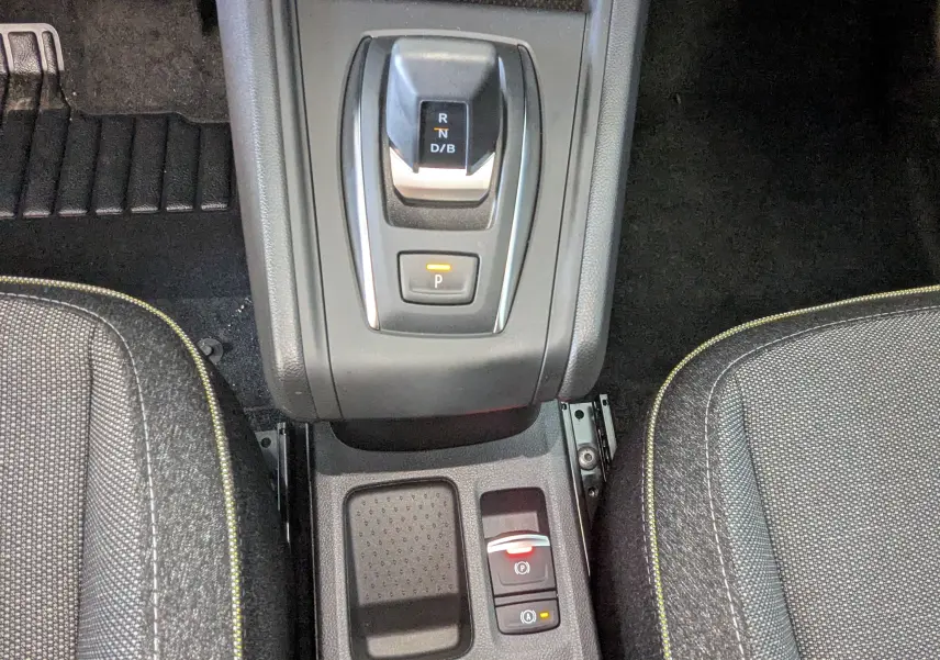 Vue plongeante sur la console centrale du Renault Captur gris Cassiopée, montrant le levier de vitesses automatique et les sièges tissu gris.