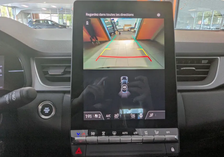 Écran central du Renault Captur E-Tech Hybrid 2025 montrant la caméra de recul avec commandes climatisation et tableau de bord gris.