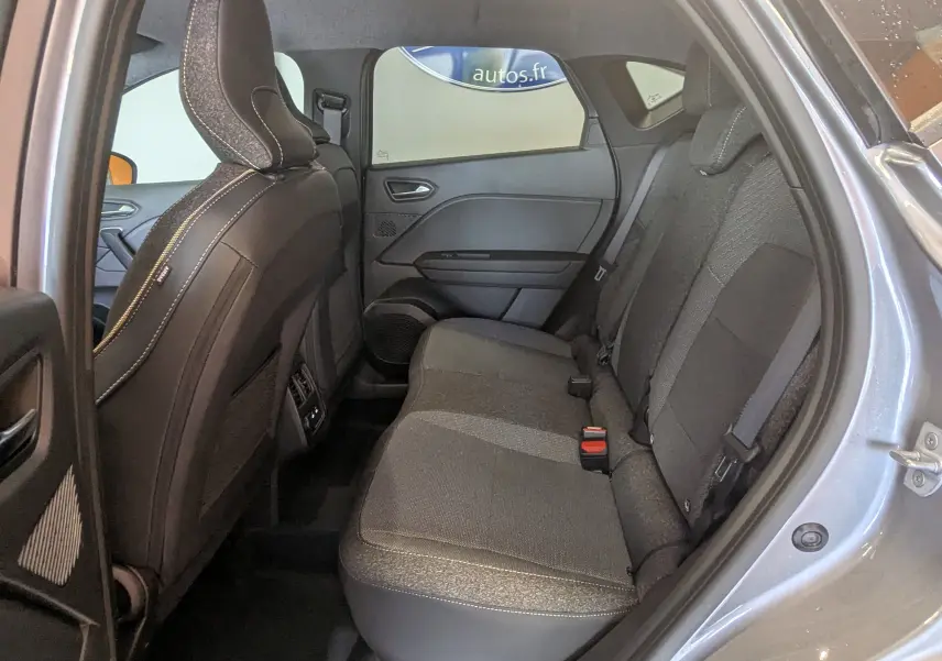 Vue côté droit de l'habitacle arrière du Renault Captur E-Tech gris Cassiopée, sièges tissu gris et ceintures visibles.