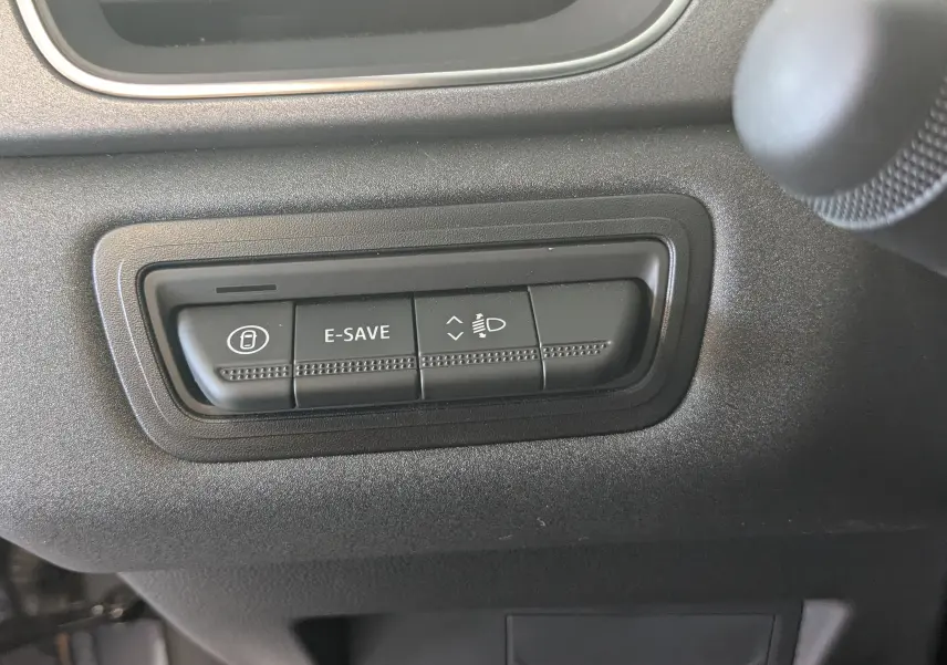 Boutons de commande noirs sur tableau de bord gris du Renault Captur E-Tech Hybrid 2025, avec fonction E-SAVE visible.