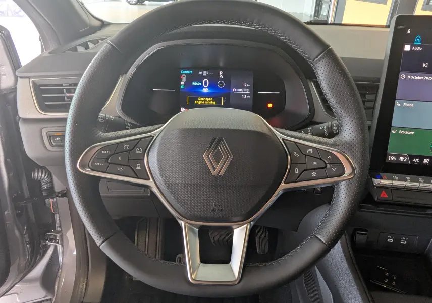 Vue rapprochée du volant multifonction noir avec logo Renault au centre du tableau de bord du Captur E-Tech 2025.