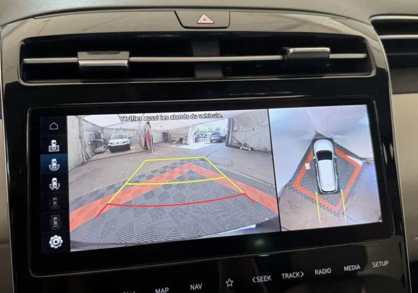 Écran tactile intérieur montrant la caméra de recul et vue à 360° du Hyundai Tucson noir en stationnement.