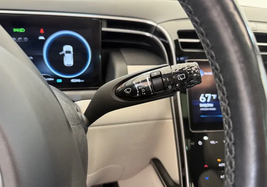 Gros plan sur la commande d'essuie-glace noire et le tableau de bord numérique du Hyundai Tucson noir 2022.