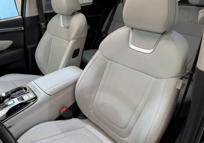 Gros plan sur les sièges avant en cuir beige clair du Hyundai Tucson 2022, avec console centrale visible.
